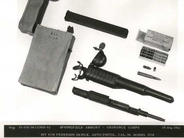 Figure 2 — Kit for the Pedersen device, as photographed by Springfield Armory in 1962: the canvas magazine case stencilled R.I.A. 7-19, a magazine, a carton of cartridges with loose rounds beside a full-size …