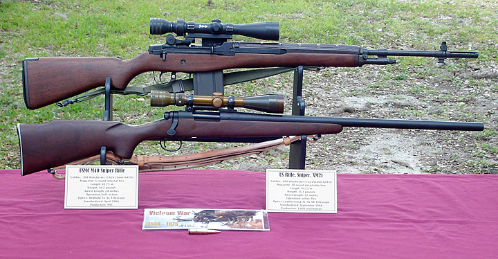 Figure 4 — Two Vietnam-era sniper rifles side by side at a display: the Army's XM21 (a modified M14, above) and the Marine M40 on its Remington 700 action (below). The display's own description states both ar…