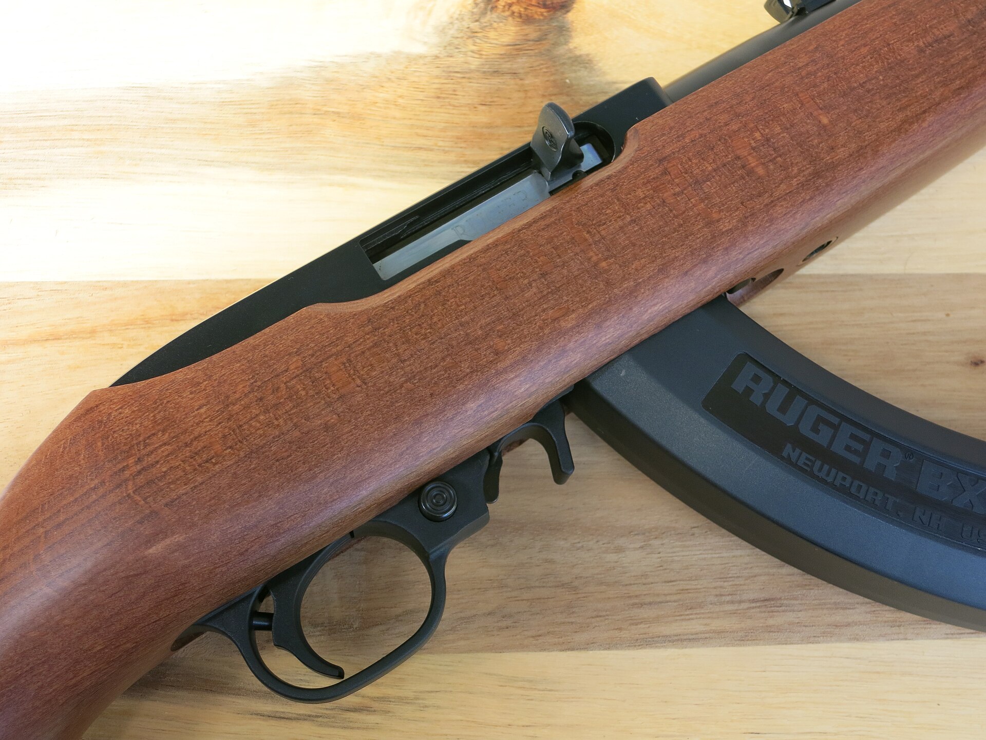 Figure 4 — A current 10/22 carbine seen from the right: the cross-bolt safety button protruding from this side of the trigger guard, which is the on position; forward of the trigger, the magazine release and …