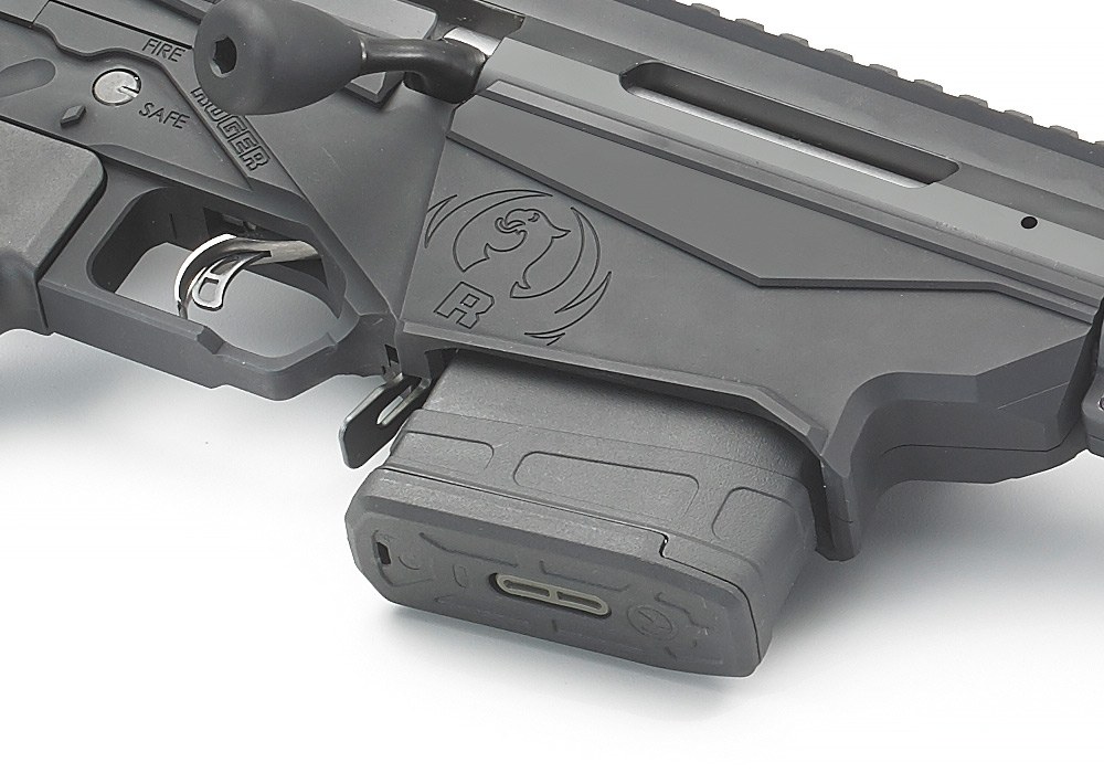 Figure 10 — The 2016 rifle's magazine well from the left, with a Magpul magazine seated, the paddle latch lever behind it, and the contoured front of the well.