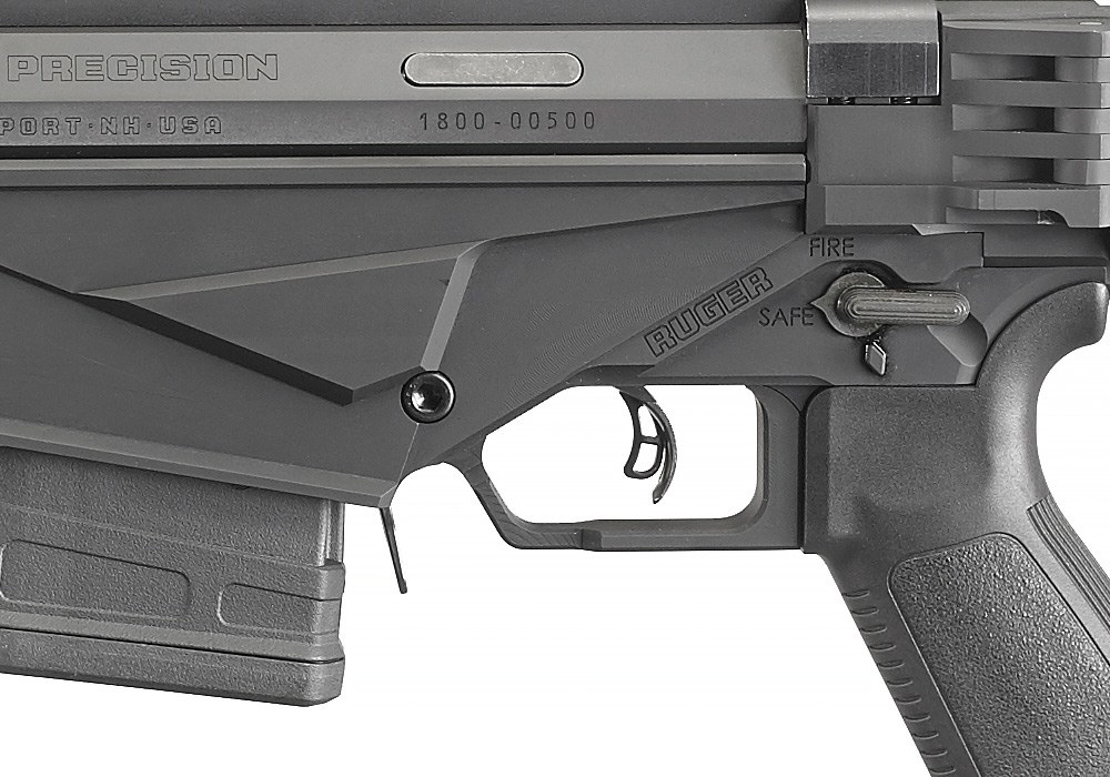 Figure 8 — The 2016 rifle's trigger and safety: the Marksman Adjustable trigger with its centre release blade, the AR-pattern grip, and the selector on the left side of the magazine well marked FIRE and SAFE.