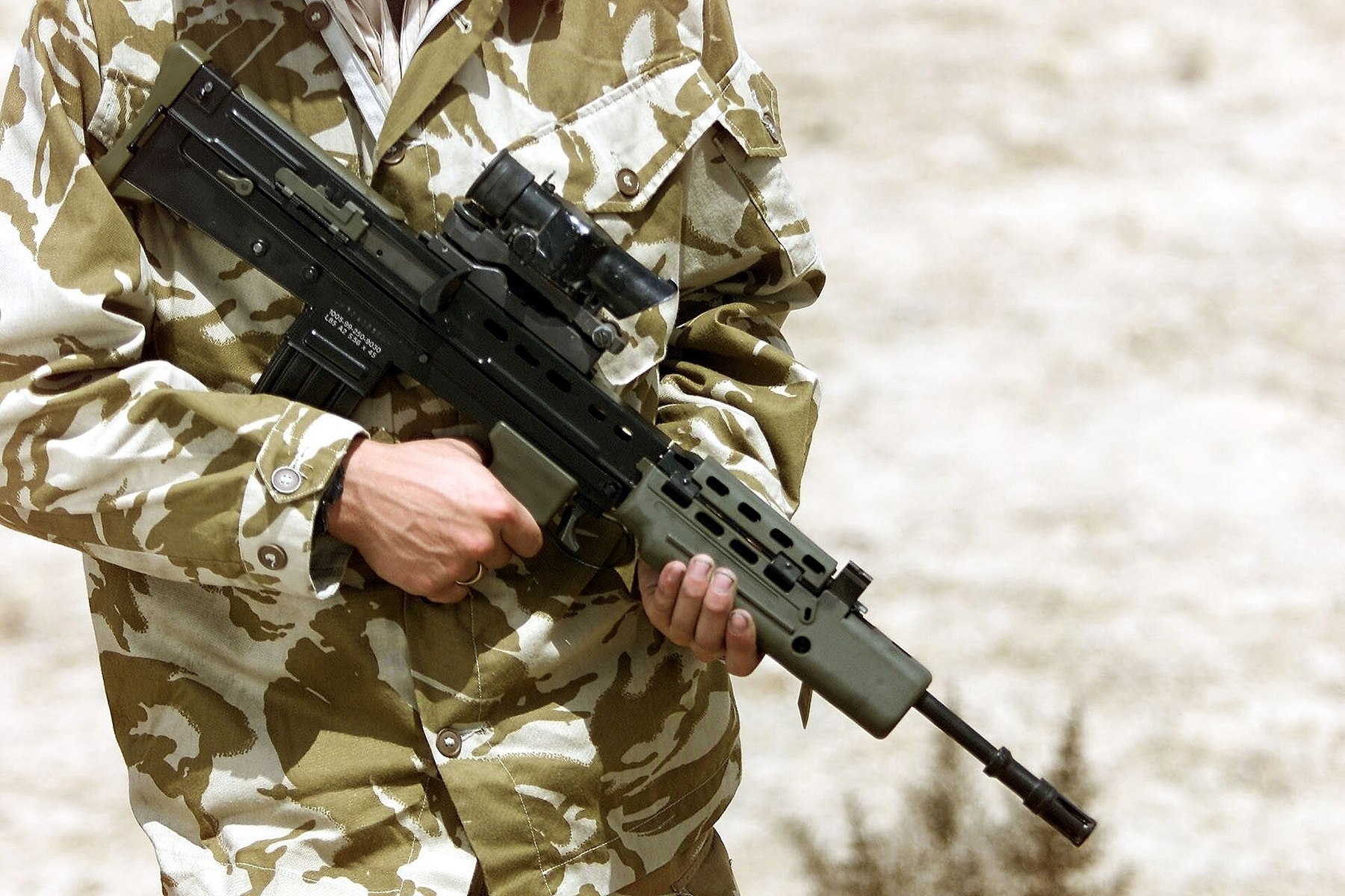Figure 3 — A soldier in desert uniform holds a modified SA80 during the climate trial in Kuwait, 2001. MOD photograph by Mike Weston, Open Government Licence v1.0.
