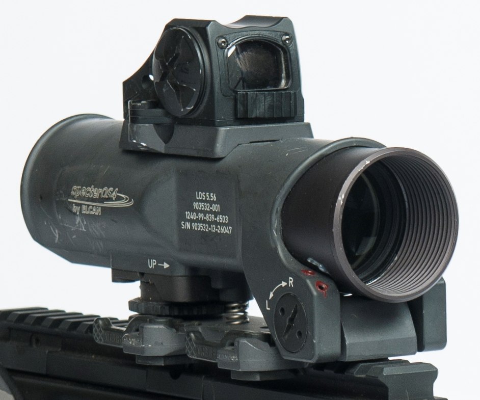 Figure 4 — The Elcan Specter OS4x, the Lightweight Day Sight, on its mount on an SA80-A2. Its body is marked "SpecterOS4x by ELCAN" and "LDS 5.56". Crop by a Commons contributor from an MOD photograph by Stua…
