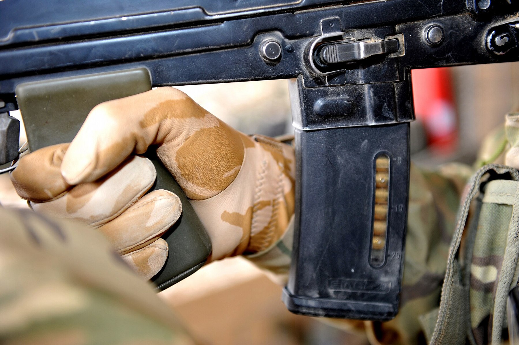 Figure 7 — A Magpul polymer magazine fitted to an SA80 in Afghanistan: the magazine catch on the left of the housing, the bolt-release button above it, and the gloved firing hand. MOD photograph by Sgt Rupert…
