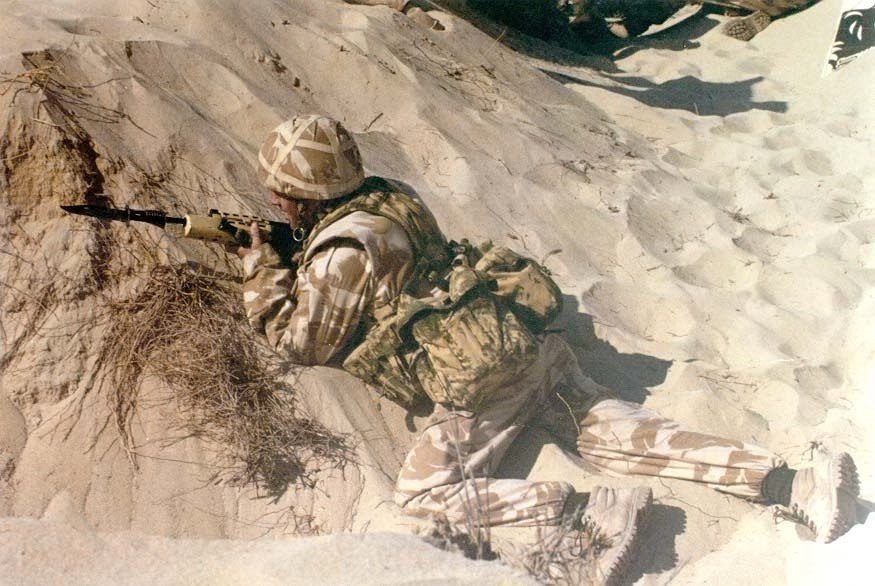 Figure 5 — A British soldier in desert uniform lying in a sand scrape with an L85A1 during Operation Granby, 1991. Photograph by PFC John F. Freund, XVIII Airborne Corps History Office, US Army, public domain.