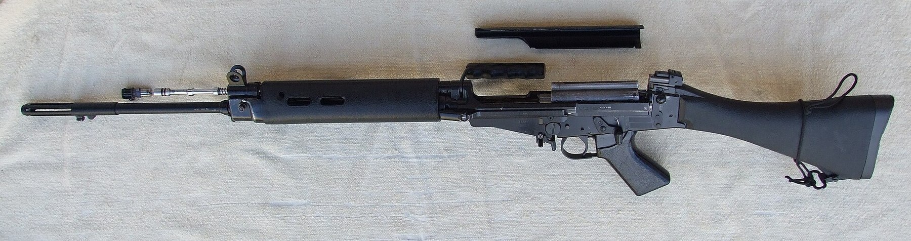 Figure 8 — An L1A1 field-stripped: receiver and barrel, the top cover, the breech block and carrier, and the return-spring rod. Public domain, via Wikimedia Commons.
