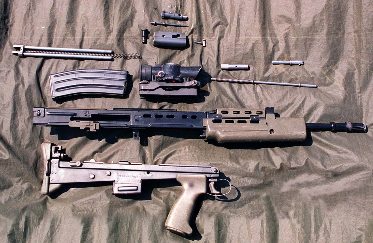 Figure 2 — An L85A1 field-stripped in 1996 into the assemblies the handbook names: body with barrel and handguard, trigger mechanism housing with butt and grip, bolt carrier group, recoil rod assembly, gas pa…