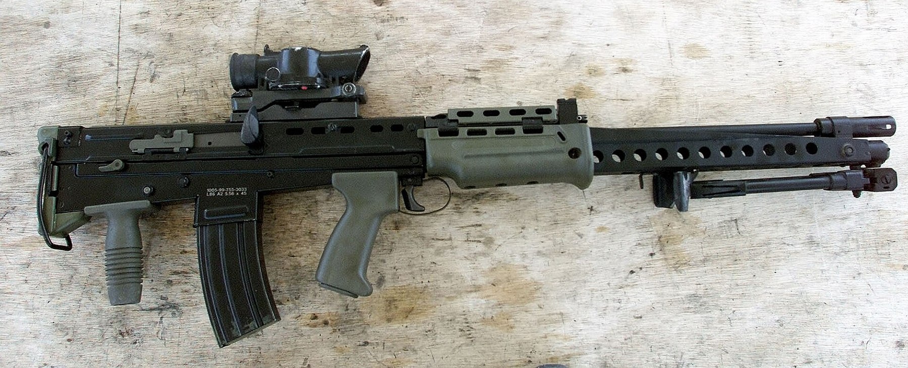 Figure 4 — A modified LSW with the new magazine on the SA80 climate trial in Kuwait, 30 May 2001: long barrel, outrigger and bipod, rear grip under the butt. MOD photograph, Open Government Licence v1.0.