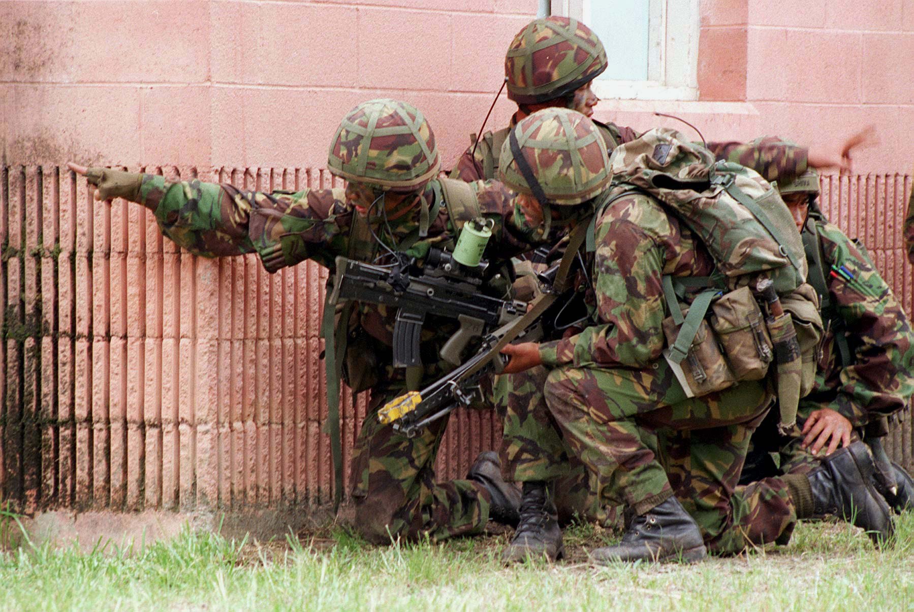 Figure 6 — A section of British soldiers with L85A1 rifles during a 1996 exercise, crouched at a building's corner. US Marine Corps photograph by Lance Cpl. C. D. Clark, public domain.