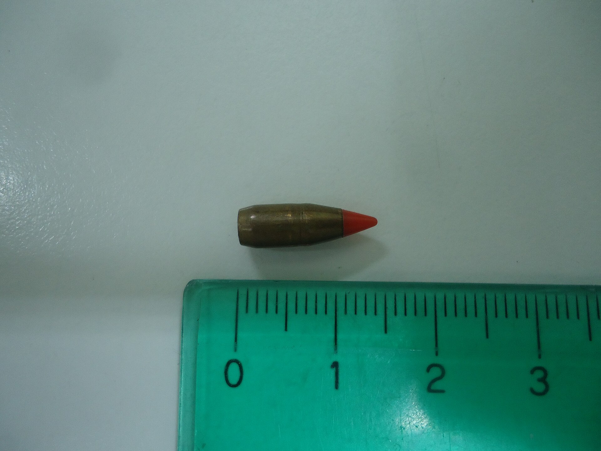 Figure 4 — The 17-grain V-MAX bullet pulled from a .17 HMR cartridge, beside a centimetre scale. The red polymer tip is the expansion initiator.