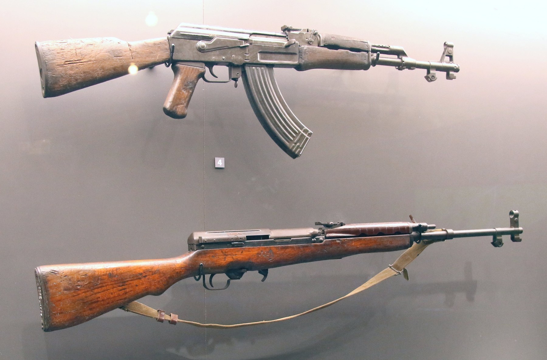Figure 5 — A K63 in the Vietnam Military History Museum, Hanoi, right side, without its magazine or bayonet, below a Type 56 AK. The magazine catch ahead of the trigger guard and the selector at its front sho…
