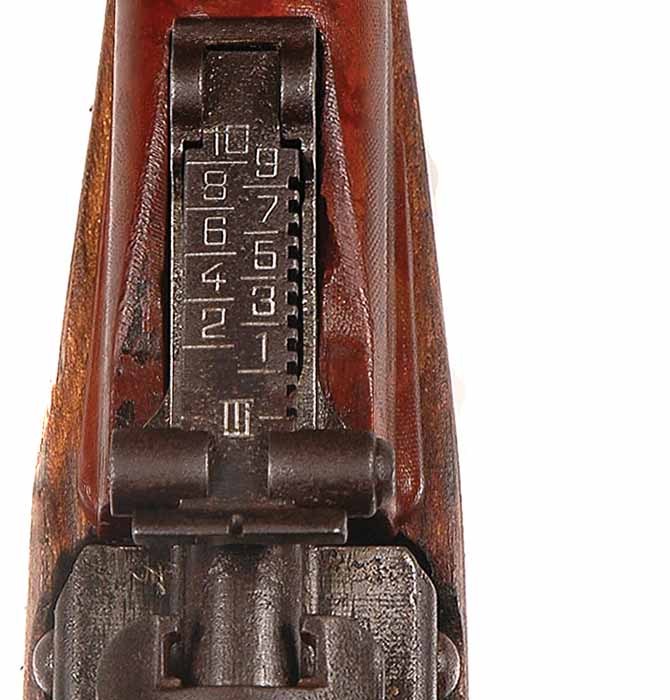 Figure 6 — The rear sight from above, graduated 1 to 10 (hundreds of metres) with the battle setting marked with a Roman III; the front of the carrier with its stripper-clip grooves is below it. From Iannamic…