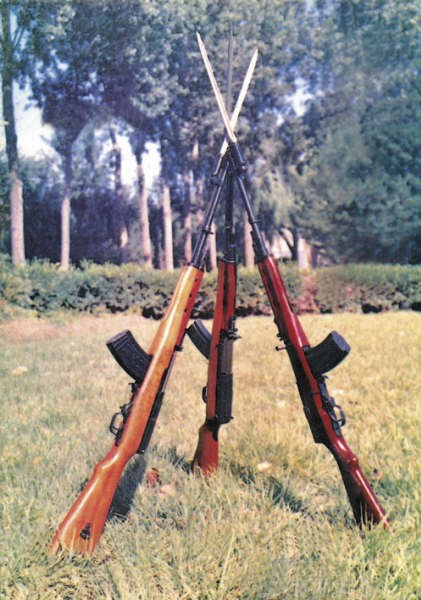 Figure 2 — Three Type 63s stacked with their spike bayonets crossed, in a colour photograph reproduced by 枪炮世界 without its original publication. The long wooden stock, the curved magazine ahead of the trigger…
