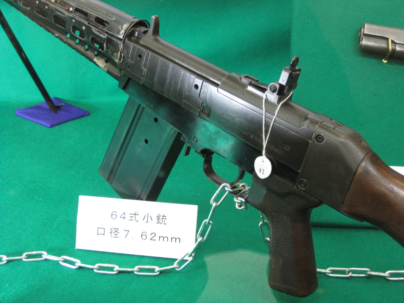 Figure 4 — The receiver of the rifle in the Camp Jinmachi museum, marked 試製, 1963 and, apparently, No. 012. The display card reads 64式小銃, 口径7.62mm. Photograph by Crescent moon, CC BY 3.0, via Wikimedia Commons.