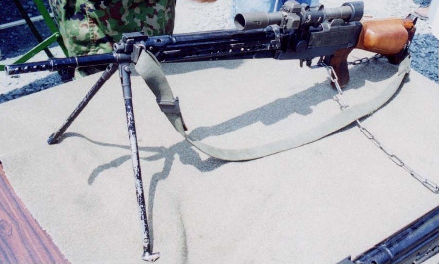 Figure 2 — A Type 64 fitted with the 2.2× sniper scope offset to the left of the receiver, with its sling, on a display table. The cheek pad is not fitted in this photograph. Photograph by Norseman5614, CC BY…