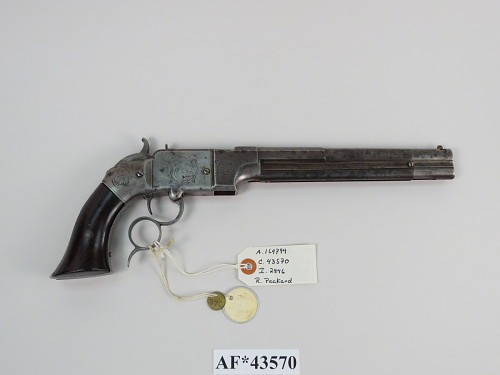 Figure 2 — A Volcanic-type pistol with an iron frame and an engraved finish, in the National Museum of American History, which catalogues it as a .38 Volcanic pistol (AF43570). An iron frame is the mark of Sm…