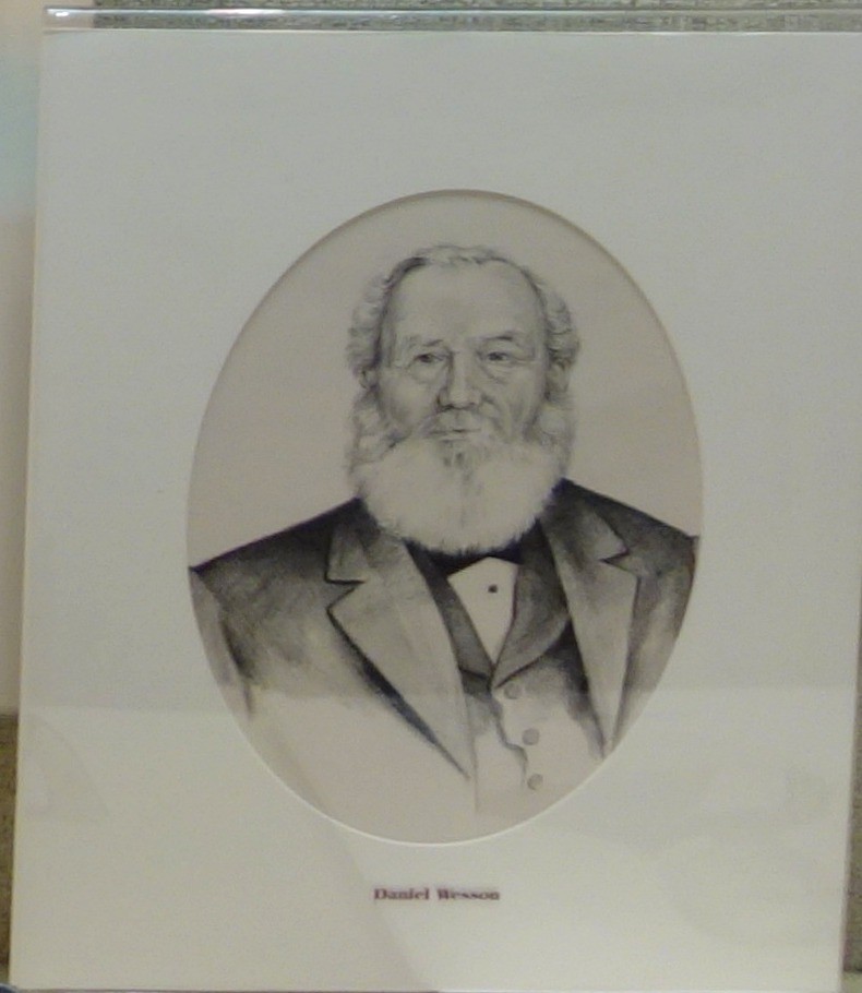 Figure 11 — Daniel B. Wesson, Smith's partner in the 1854 toggle-action patent: a drawn portrait labelled "Daniel Wesson" in the case "Men Who Made the Gun" at the Huntington Museum of Art, West Virginia. The …