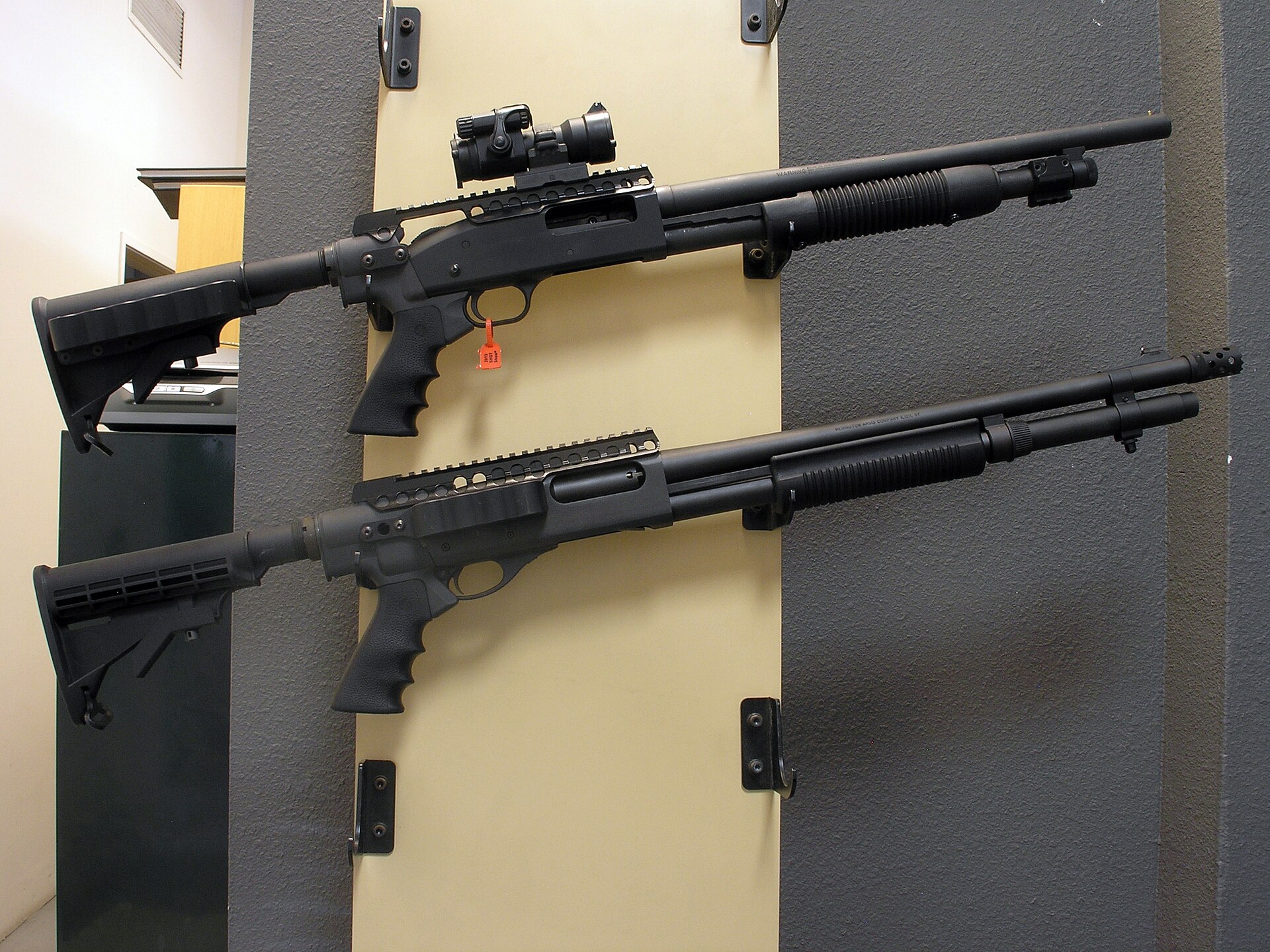 Figure 4 — A Mossberg 500, top, and a Remington 870, bottom, each set up with a collapsible AR-pattern stock, a pistol-grip adapter and a receiver rail; the Mossberg carries a tube red dot. The two guns take …