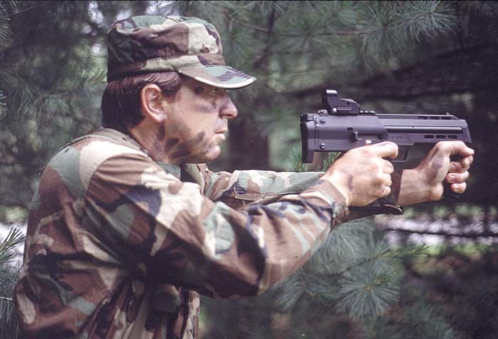 Figure 6 — The PDW prototype fired two-handed like a pistol, from Small Arms Review, April 2001. Its caption: "Engagement times from the holster for a proficient operator are on par with those of a convention…