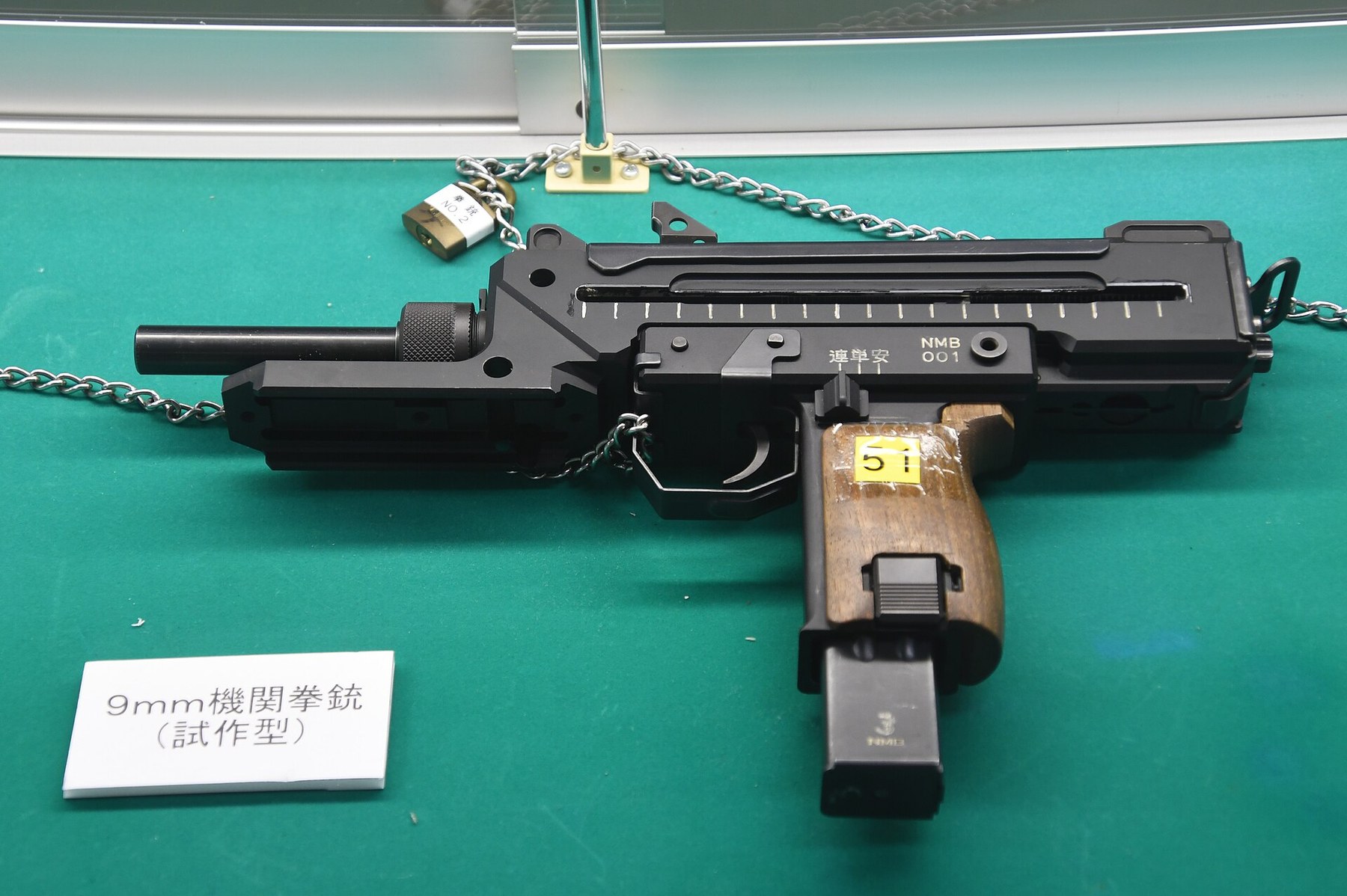 Figure 4 — The M9 prototype in the Camp Tsuchiura museum, September 2025, left side. It has wooden grip panels and no foregrip, and its selector markings differ from production guns. Photograph by Hunini, CC …