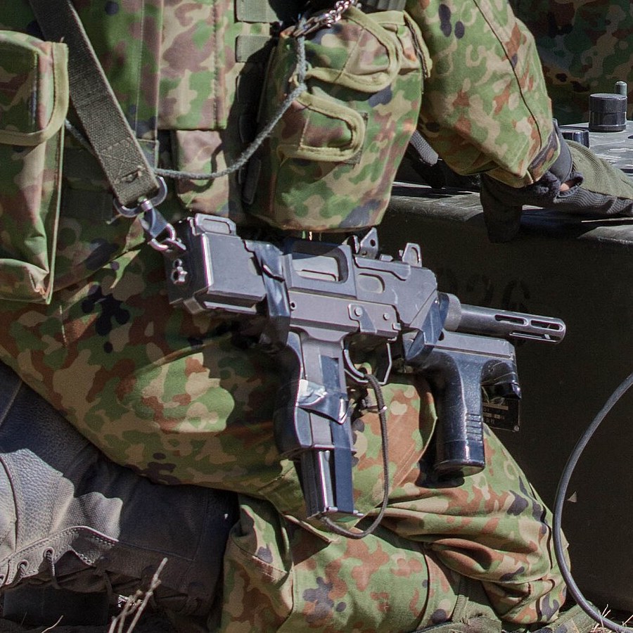 Figure 3 — A Ground Self-Defense Force soldier with an M9 at Yakima Training Center, Washington, during a demonstration for the commanding general of the Eastern Army, 5 September 2014. The weapon hangs on a …