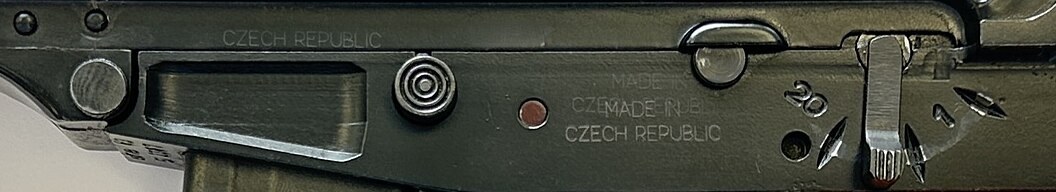 Figure 4 — The left of the body of the vz. 61 in panel A: CZECH REPUBLIC above the magazine catch, a double-struck MADE IN ... CZECH REPUBLIC, and the selector figures. Crop of a photograph by Land68, CC0, vi…
