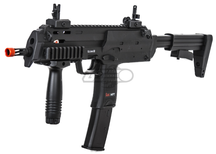 Figure 7 — The Elite Force H&K MP7 Sport AEG. The receiver is MP7-shaped, but the stock is an M4-type collapsible stock on a buffer-tube-style mount, and the vertical grip is an add-on rather than the MP7's f…