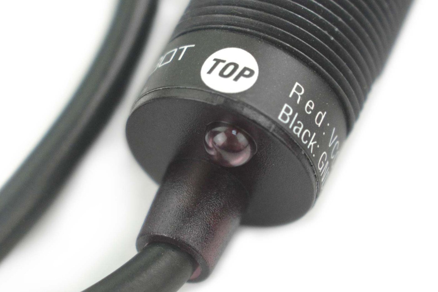 Figure 6 — The DFRobot SEN0158 seen from the cable end, showing the printed "TOP" mark and the wire legend on the body. The mark sets the camera's rotation in the barrel; a camera mounted rotated reports a ro…
