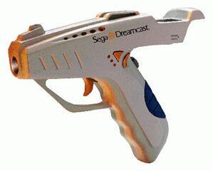 Figure 3 — The Mad Catz Dream Blaster, the licensed North American Dreamcast gun, in silver with orange and blue accents and the Sega Dreamcast logo on the barrel. Sega Retro describes it as the only third-pa…