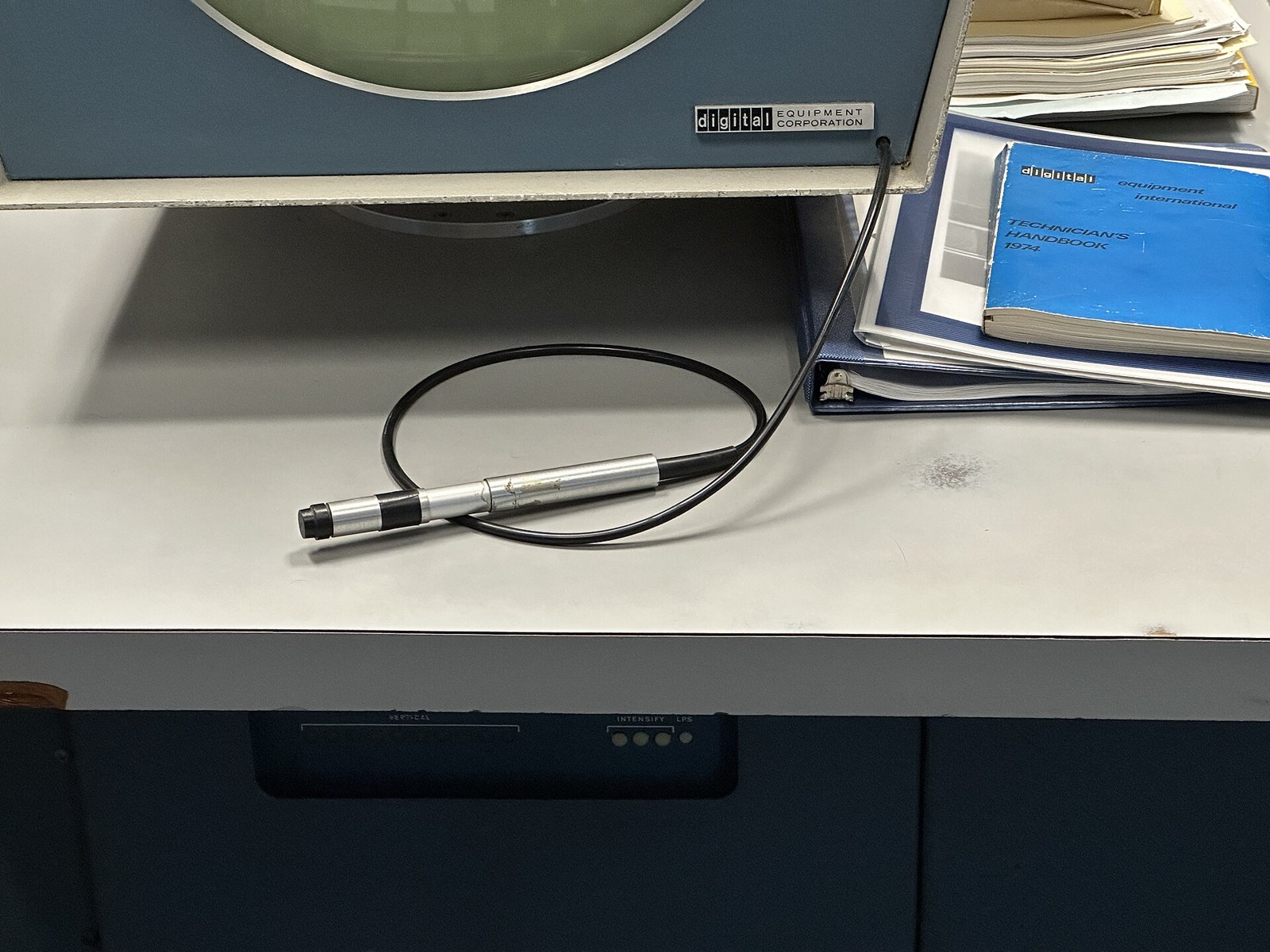 Figure 6 — The light pen of a DEC PDP-1 display, on the console desk at the Computer History Museum: a metal pen body on a coiled cable. Photo: ArnoldReinhold, Wikimedia Commons, CC BY 4.0.