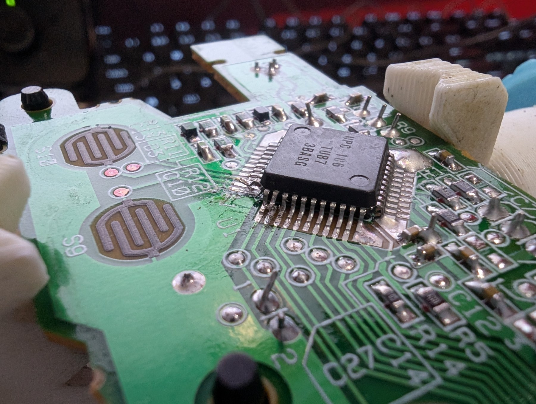 Figure 5 — The main board with three pins of the large square IC lifted from their pads, isolating the A, Start and Select contacts from the original electronics. Photo: The Opponent, 28 July 2025, CC0.