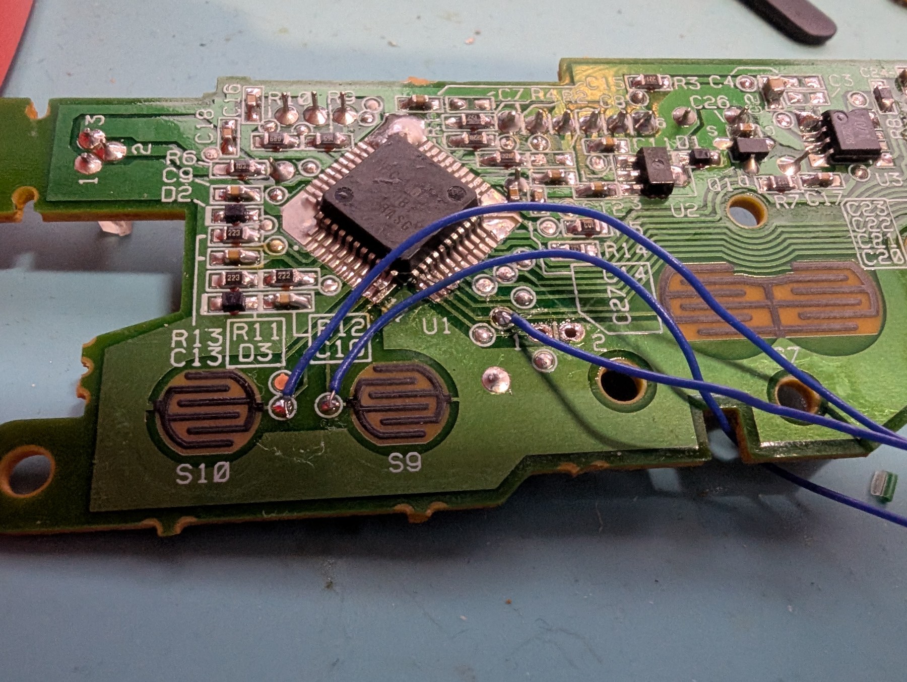 Figure 6 — The main board with 30 AWG wires on the test pads for the A, Start and Select buttons, routed clear of the rubber-dome contacts. Photo: The Opponent, 28 July 2025, CC0.