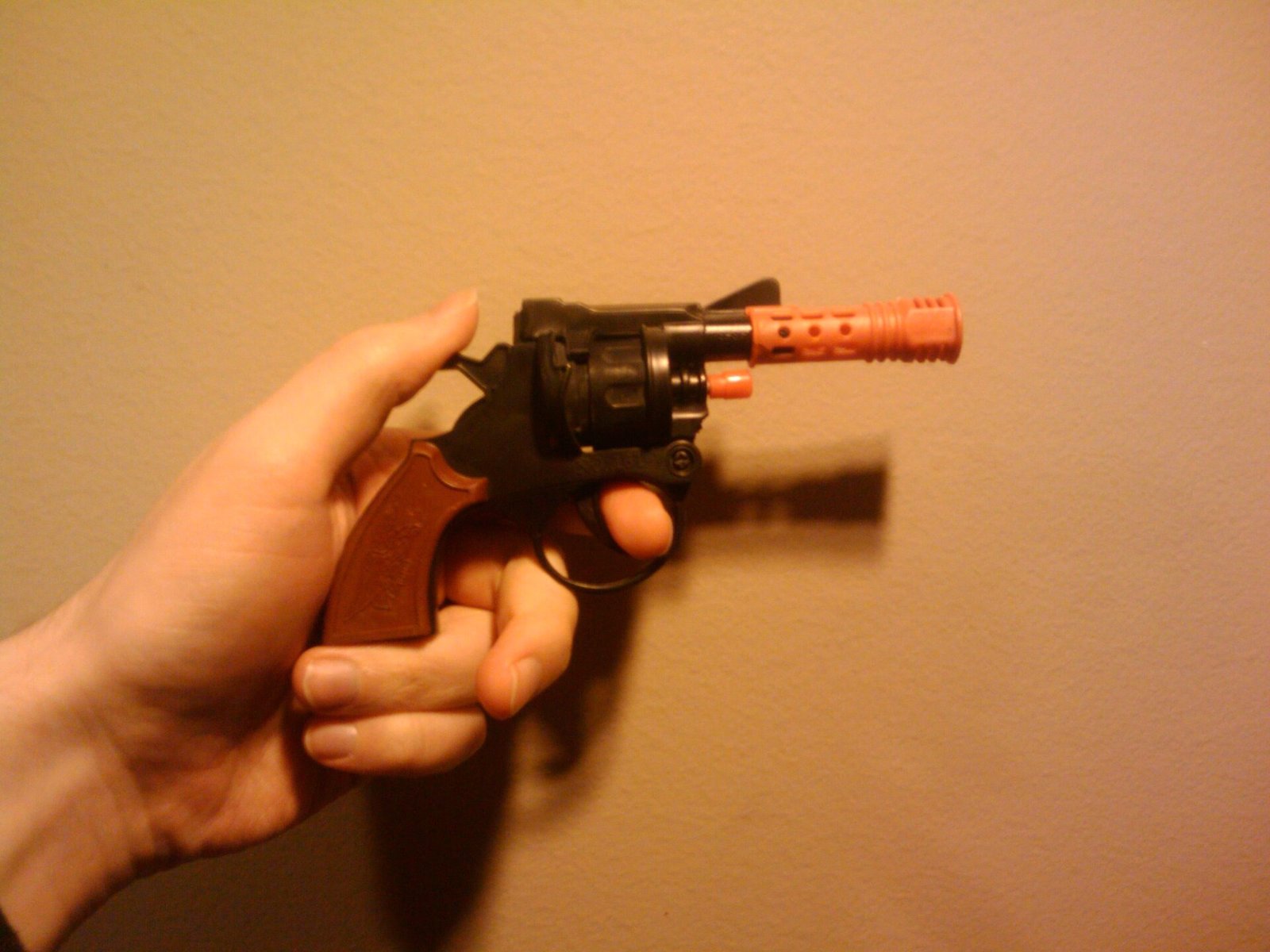 Figure 3 — A cap-gun revolver with an orange barrel extension: a toy marked by an orange part that covers the barrel's circumference at the muzzle, the same idea as option (b). Photo: Mike Prosser, Wikimedia …
