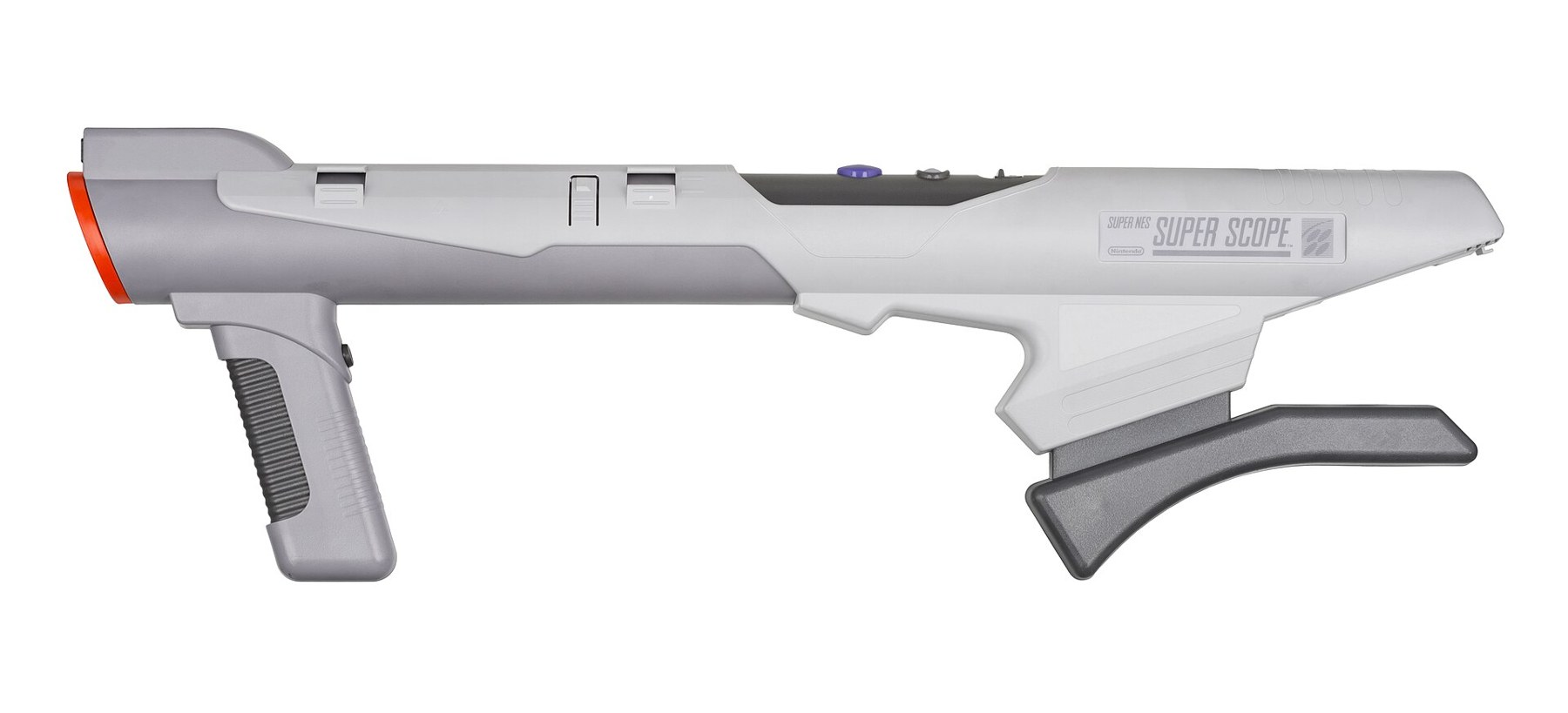 Figure 3 — The SNES Super Scope, a grey shoulder-fired bazooka-shaped gun with a red muzzle cap. It is wireless: its sensor and trigger signals reach a receiver plugged into the console's second port, and tha…
