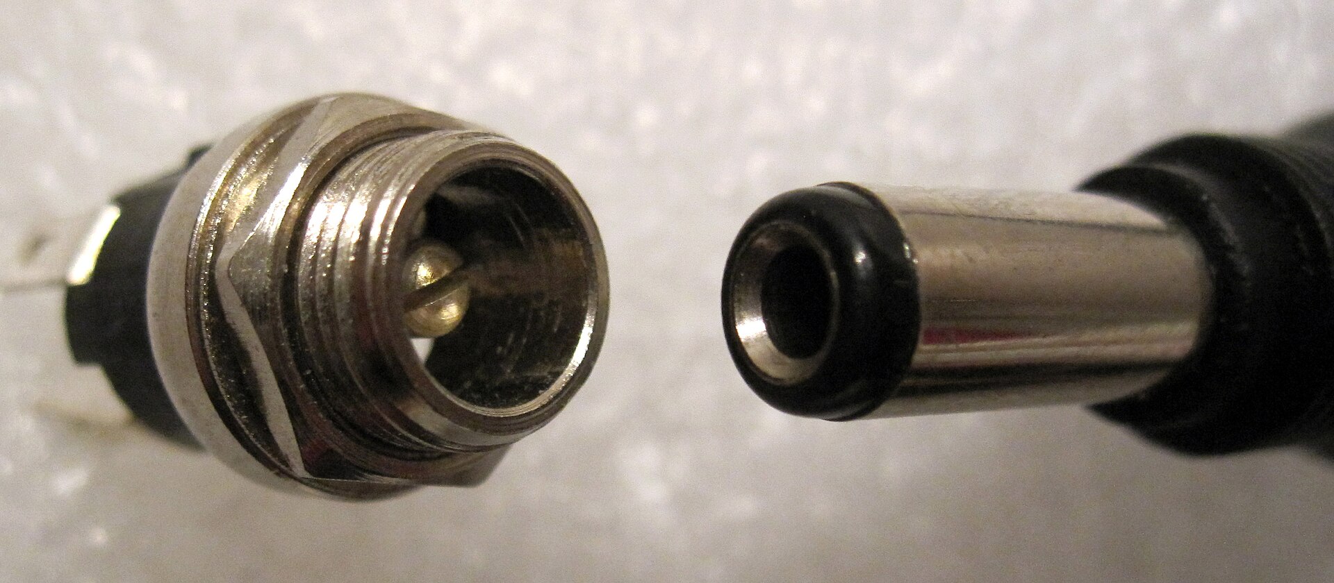 Figure 3 — A panel-mount barrel jack beside a plug, here the 5.5 by 2.5 mm size. A 2.5 mm plug will slide onto a 2.1 mm centre pin, but it contacts the pin only along one side and makes an intermittent connec…