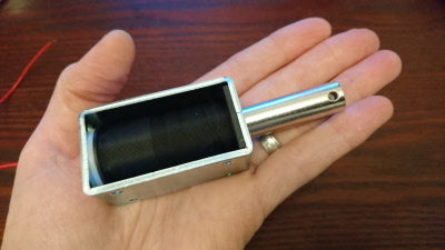 Figure 5 — The solenoid from Sinden's recoil gun, an open-frame push-pull coil. Its voltage, resistance and the capacitor and boost voltage that feed it are not published. Photo: Sinden Lightgun shop.