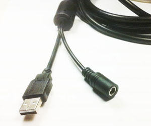 Figure 12 — The recoil connection on Ultimarc's AimTrak: the gun's harness ends in a USB-A plug and a DC barrel socket, so one cable to the gun carries both the USB link and the solenoid supply. Photo: Ultimarc.