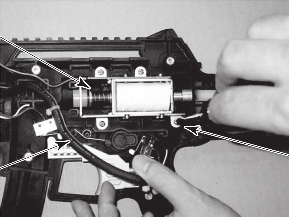 Figure 9 — The Ghost Squad gun with its left cover removed, from the operator's manual. The solenoid assembly is an open-frame unit with an external spring on the plunger, screwed into the receiver in line wi…
