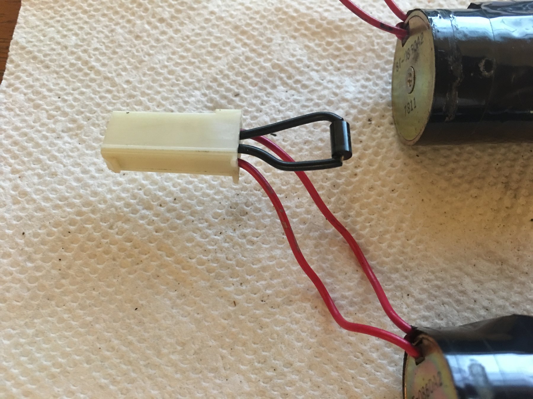 Figure 5 — The Time Crisis II solenoid harness connector. A flyback diode is soldered across the two leads inside the connector shell, so the protection travels with the solenoid rather than living on the I/O…