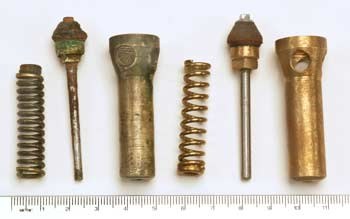 Figure 4 — The valve parts of the Beeman rifle (left three) beside the copies Ernest Cowan made for his museum reproductions (right three): coil spring, spindle with its leather head, and valve body. The orig…