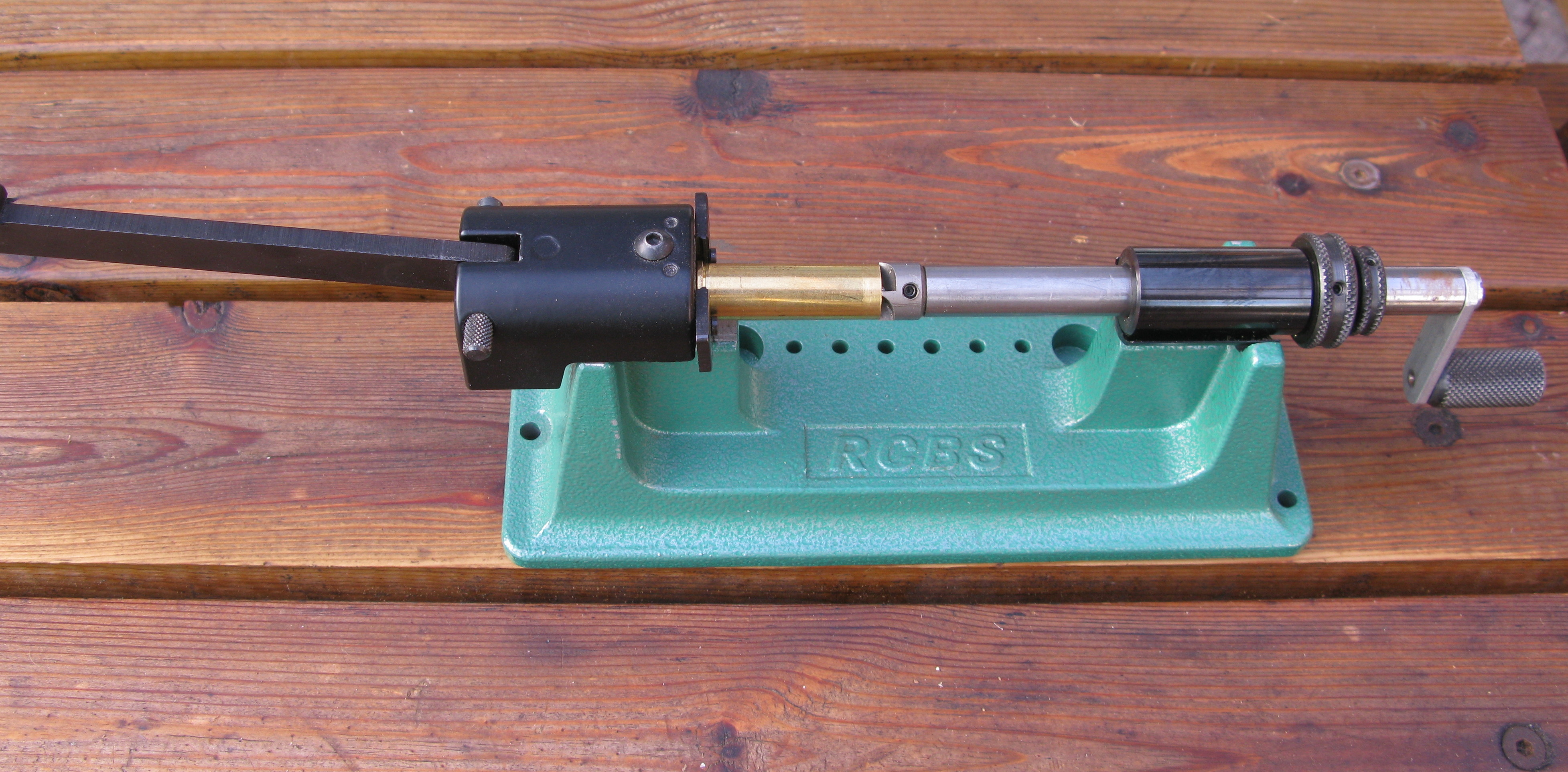 Figure 2 — A manual case lathe with a case held in the head and the cutter at the mouth. The source page names no maker, so no brand is claimed here. This is the archetype the whole tier comparison is measure…