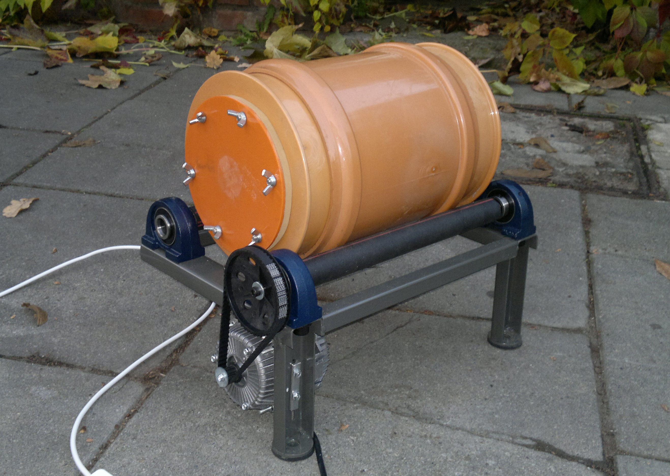 Figure 2 — A rotary tumbler with its sealed drum, the machine class the stainless-pin method requires. Paired against the vibratory bowl, the two methods are immediately distinguishable by their containers. P…